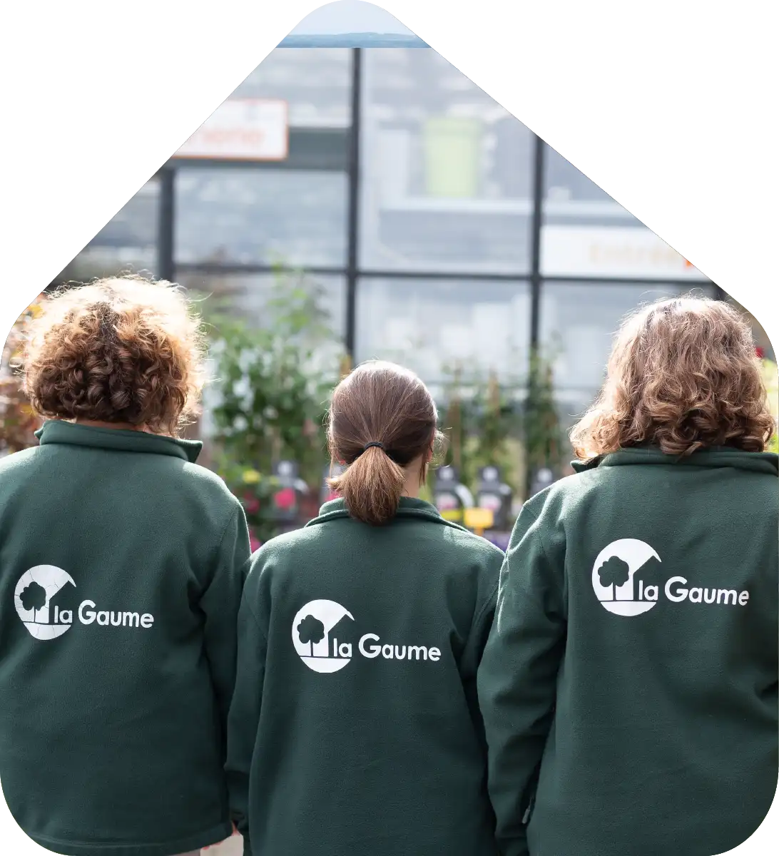 3 femmes de dos en gilet vert avec le logo de l'entreprise la gaume